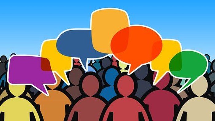 Eine Gruppe von Menschen mit Sprechblasen in verschiedenen Farben über ihren Köpfen