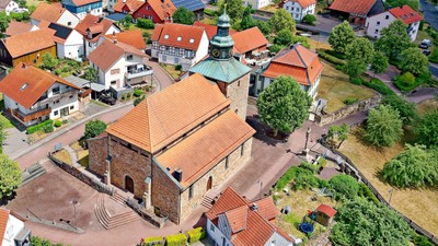 Ein Luftbild einer kleinen Stadt mit einem historischen Kirchgebäude im Mittelpunkt.