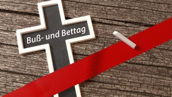Ein schwarzes Kreuz mit weißem Rand und der Aufschrift 