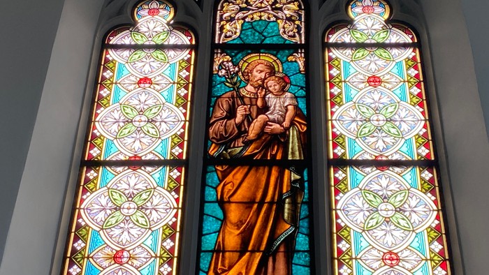 Buntes Kirchenfenster mit religiöser Darstellung