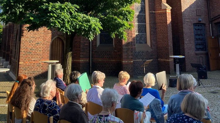 Menschen singen vor einer Kirche