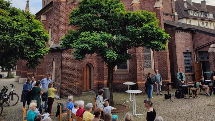 Chorprojekt Sommerserenade - Einige Menschen stehen im Innenhof der Martinskirche