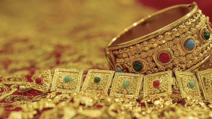 Goldschmuck mit Edelsteinen auf rotem Stoff