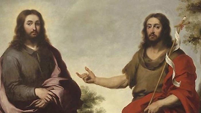 To skæggede figurer i historiske gevandter, den ene gestikulerende, mens den anden holder en stav med et kors.