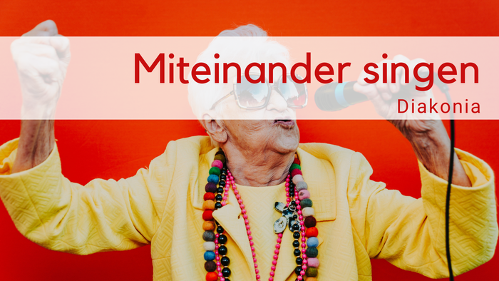Weißhaarige alte Frau mit cooler Brille, gelbem Oberteil, bunten Ketten singt mit Mirkofon auf rotem HIntergrund