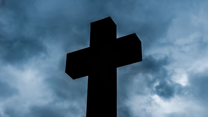 Kreuz vor bewölktem Himmel