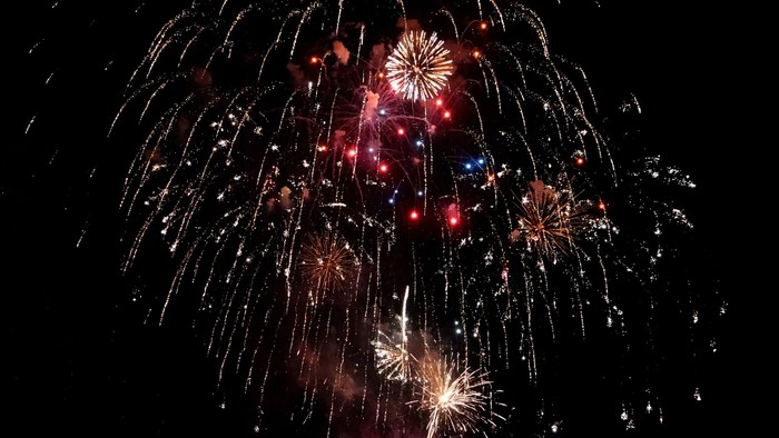 Feuerwerk explodiert am Nachthimmel und zeigt leuchtende Farben und Muster.