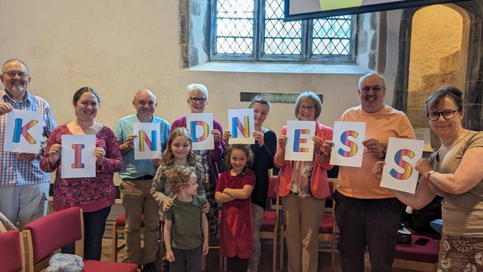 Group of people holding letters spelling 