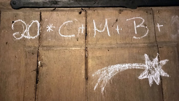 Auf einer Holzwand steht die Gleichung 30*C+M+B+ und ein Stern.