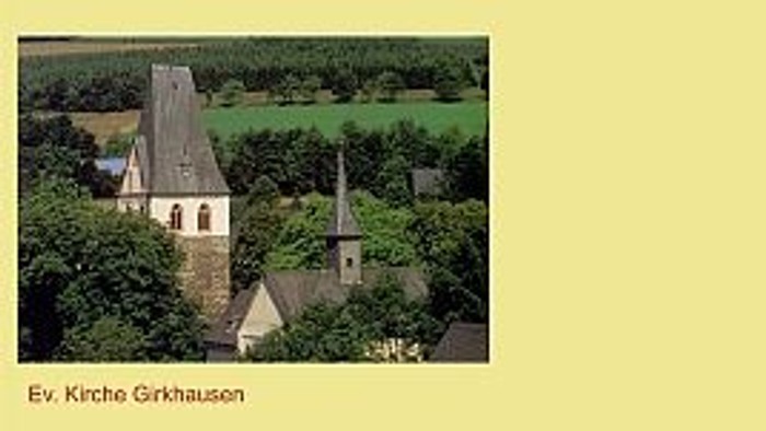 Ein altes Gebäude umgeben von Bäumen und Grünflächen