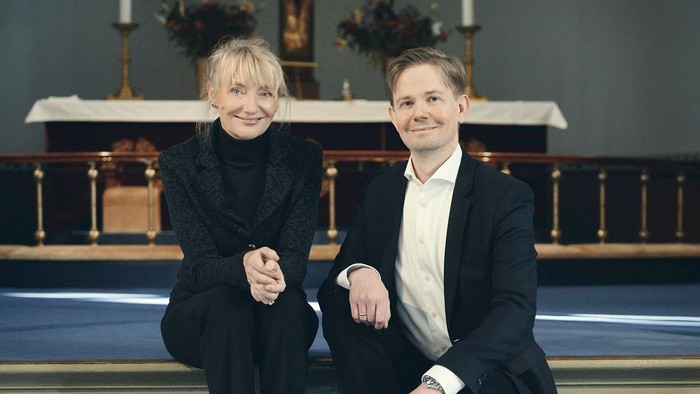 En mand og en kvinde sidder på tronen i en kirke.