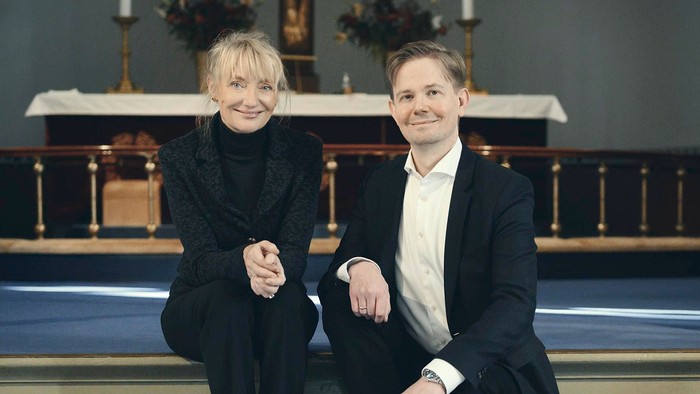 En mand og en kvinde sidder på tronen i en kirke.