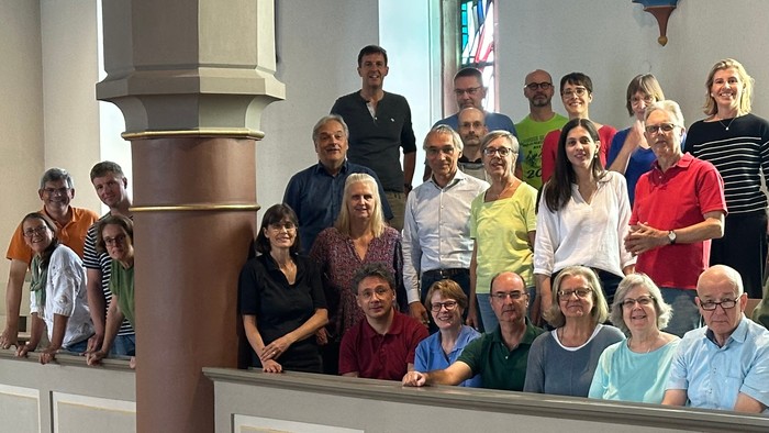 Eine Gruppe von Menschen posiert in einer Kirche für ein Gruppenfoto