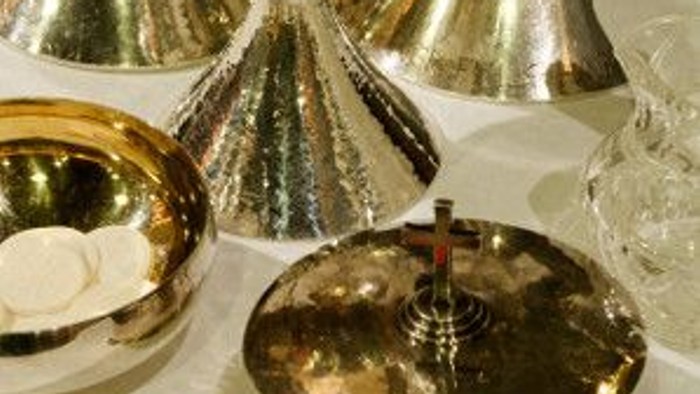 Verschiedene silberne und goldene Pokalen und Schalen auf weißem Tisch