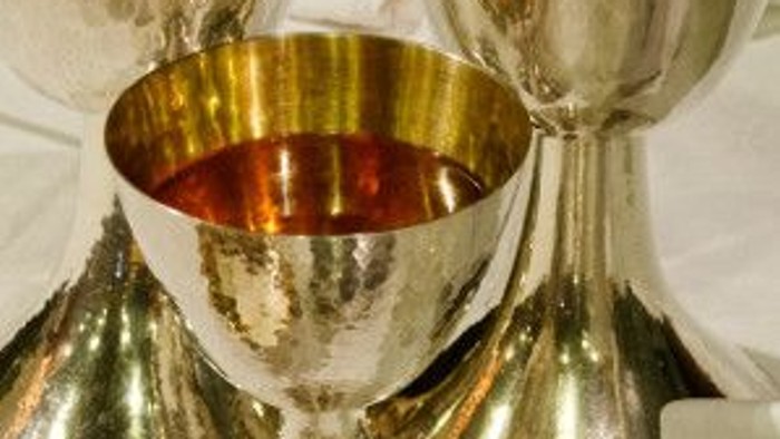 Verschiedene silberne und goldene Pokalen und Schalen auf weißem Tisch