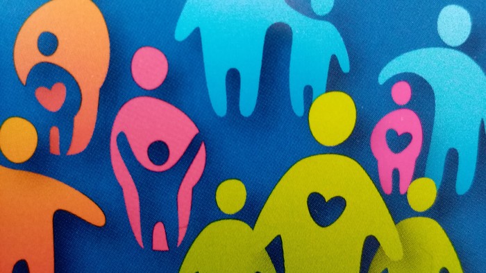 Bunte Figuren stehen in einer Gruppe zusammen