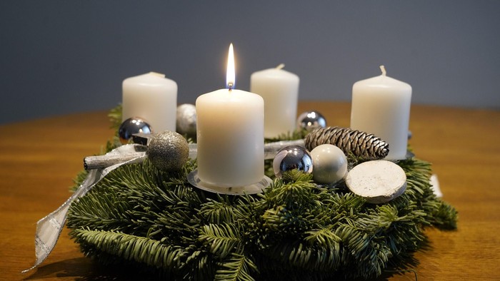 Adventskranz mit einer brennenden Kerze