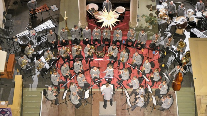 Eine Kirchenchor singt Weihnachtslieder, umgeben von Weihnachtsdekorationen.