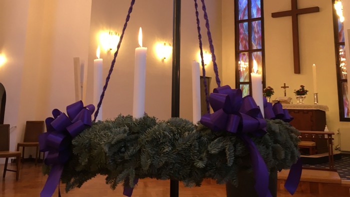 Kirkeinteriør med dekoreret stativ og stearinlys