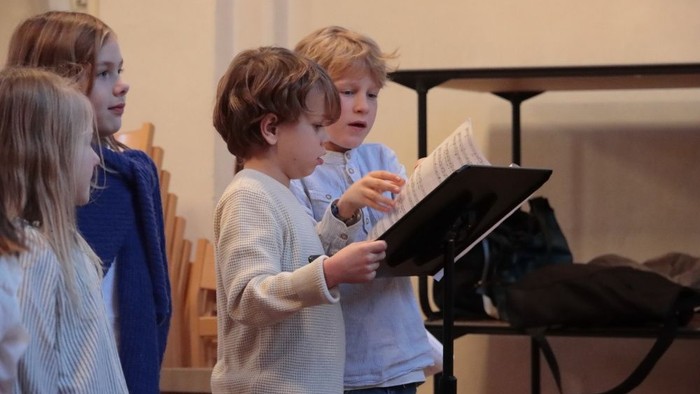 Kinder singen gemeinsam aus Notenblättern