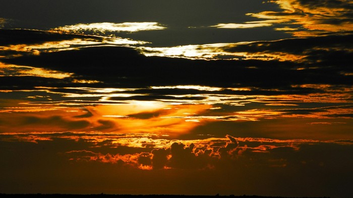 En rødgul solgang over et vandløb
