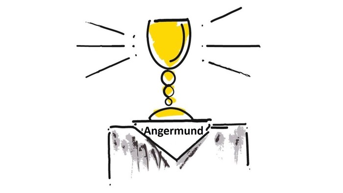 Ein Glas Wein steht auf einem Tisch mit der Aufschrift "Angermund".