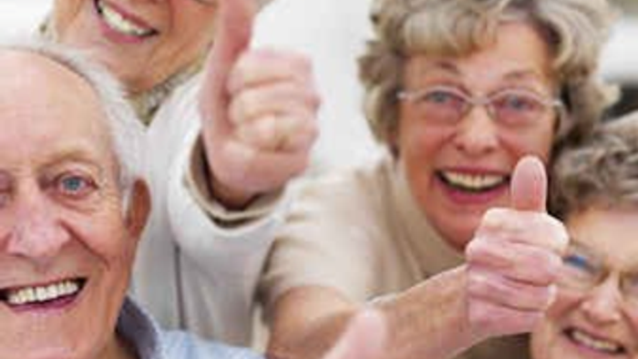 En gruppe glade og gamle mennesker giver tums op.