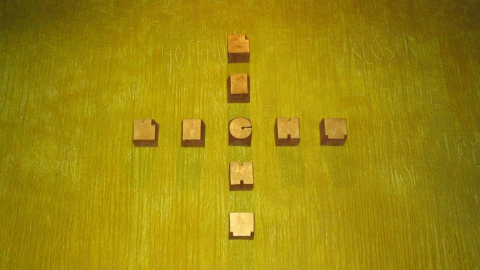 Holzblöcke mit Buchstaben auf grüner Oberfläche