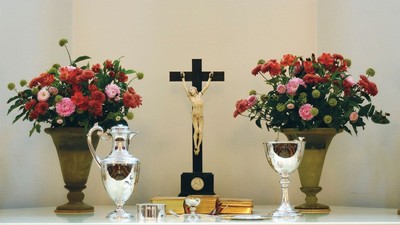 Altaret er dekket med blomsterarrangementer og religiøse symboler