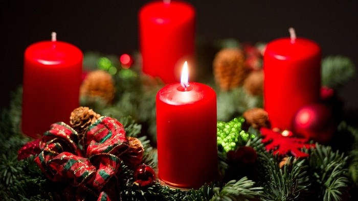 Weihnachtsdekoration mit vier brennenden Kerzen und Tannenzweigen