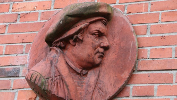 Relief eines Mannes mit Hut an Ziegelmauer