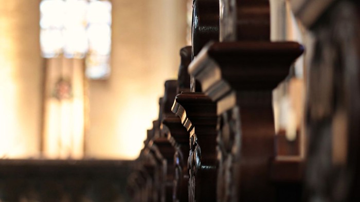 Eine Reihe von Kirchenbänken in einer Kirche.