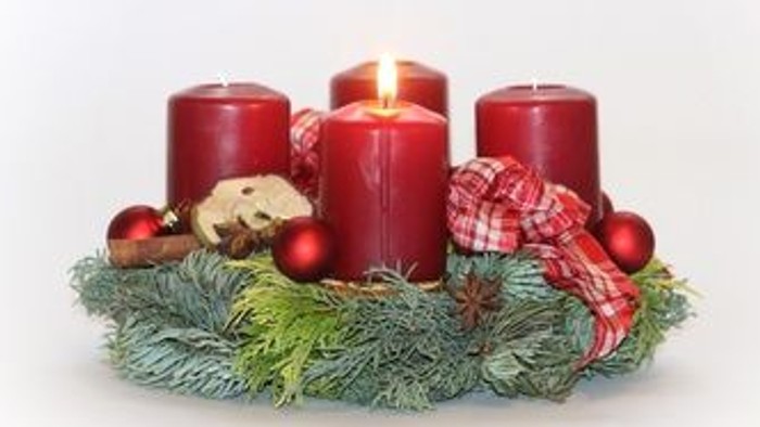 Weihnachtsdekoration mit vier Kerzen und Tannenzweigen