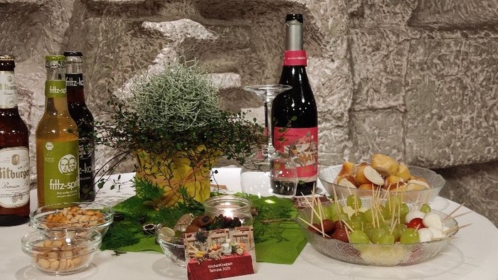 Ein Tisch mit verschiedenen Snacks, Getränken und einer Vase mit Blumen