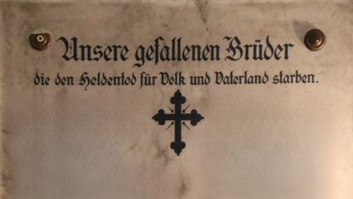 Gedenktafel mit Kreuz und Inschrift in deutscher Sprache