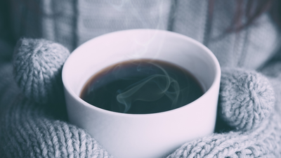 En hvid tekop i en uldet skærm med røg.