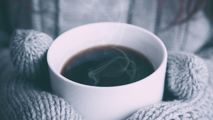 En hvid tekop i en uldet skærm med røg.