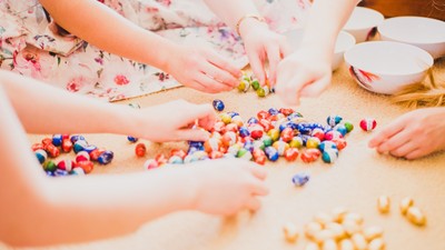 Kinder spielen mit bunten Bauklötzen auf dem Boden.