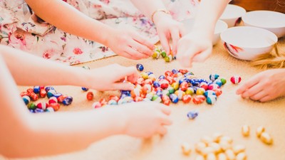 Kinder spielen mit bunten Bauklötzen auf dem Boden.