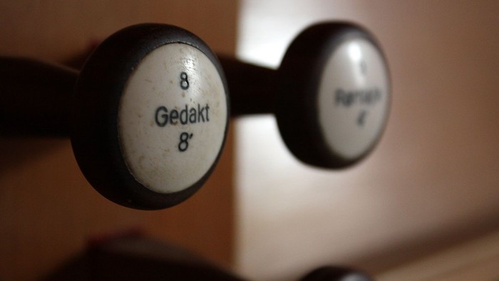 Nærbillede af vintage håndvægte med vægtangivelser på tysk, hvor der står 