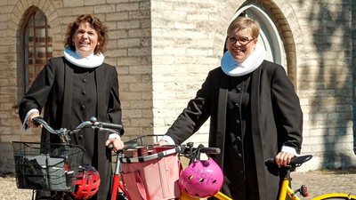 To nonner på cykler foran murstensbygning