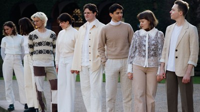 Gruppe af mennesker i hvidt tøj, der står på række.