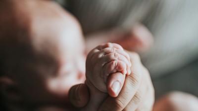 Ein schlafendes Baby liegt auf einer weichen Decke.