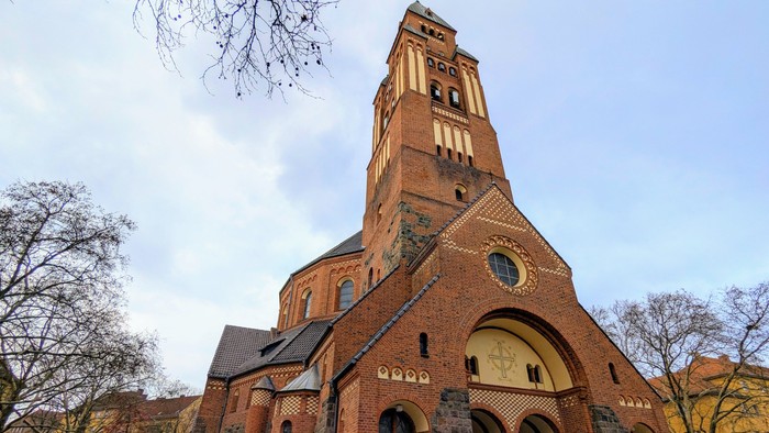 Große Ziegelkirche mit hohem Turm und Rundbogenfenster