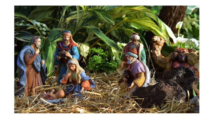 Eine Krippe mit Figuren in einer grünen Umgebung