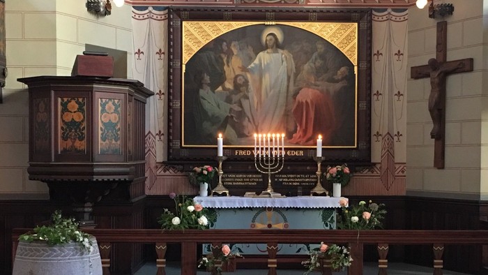 Alter i kirke med altertavle og lysestage