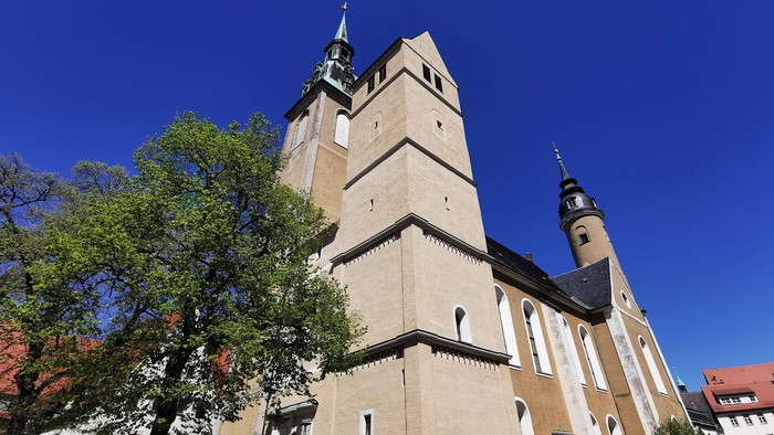 Große Kirche mit zwei Türmen vor blauem Himmel