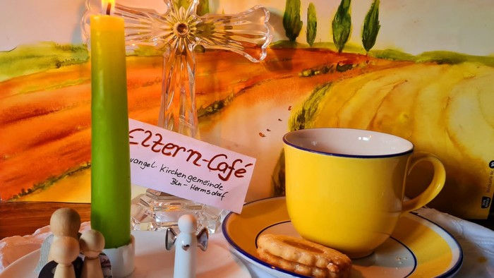 Gemütliches Café-Setting mit Kerze, Tasse und Lebkuchen