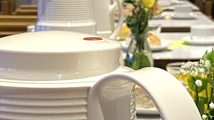 Weiße Teekannen auf Tisch mit Blumen