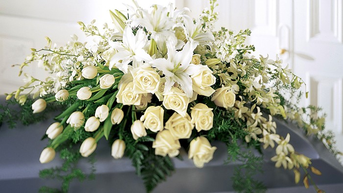 A floral arrangement with white roses and lilies.